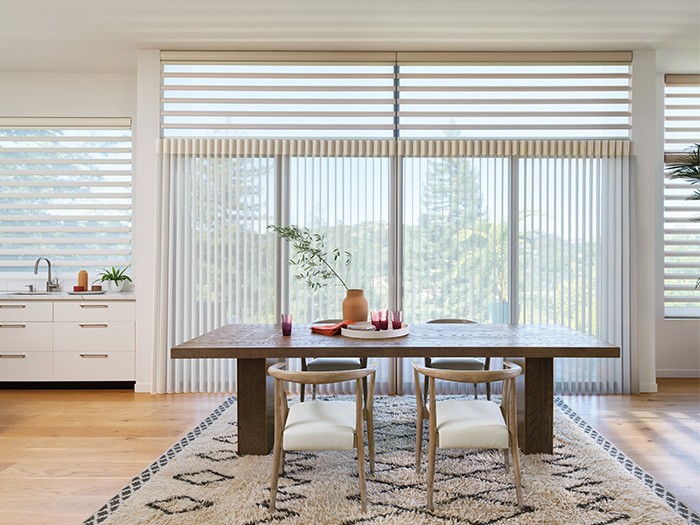 Dining room featuring sliding glass doors with Luminette® Privacy Sheers.